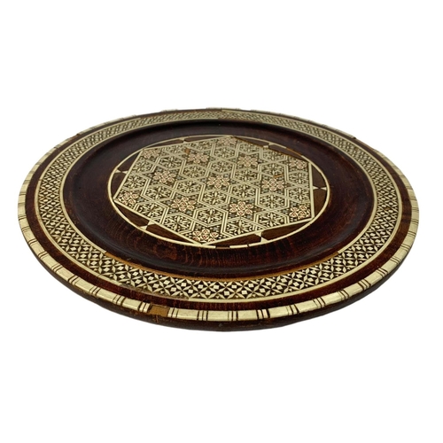 558 - Far Eastern picture and inlaid wooden charger. 34cm