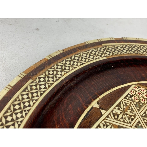 558 - Far Eastern picture and inlaid wooden charger. 34cm