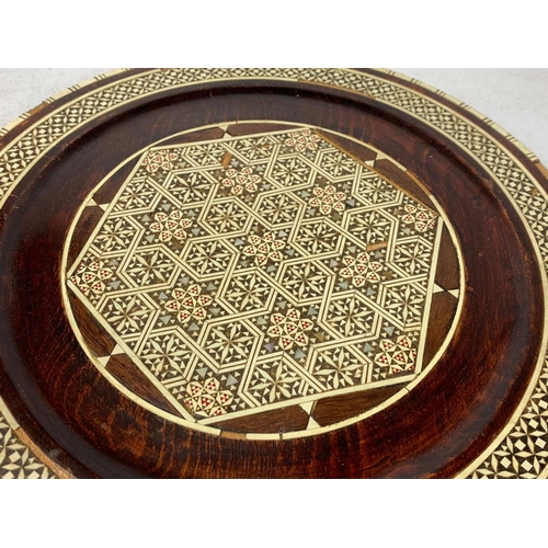 558 - Far Eastern picture and inlaid wooden charger. 34cm