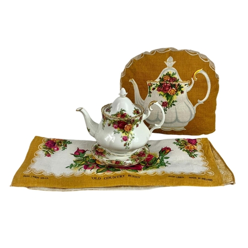 569 - Royal Albert Old Country Roses teapot on stand with tea cozy and towel. Pot measures 22 x 17cm