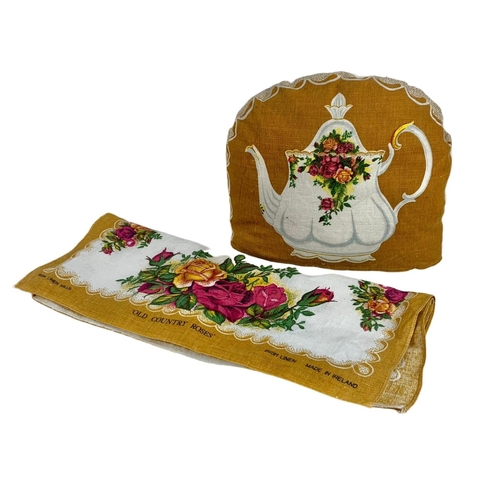 569 - Royal Albert Old Country Roses teapot on stand with tea cozy and towel. Pot measures 22 x 17cm