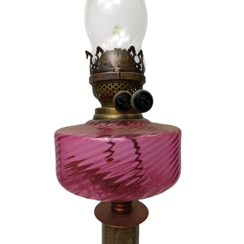 82 - Late 19th century double burner oil lamp with cranberry glass bowl, 69cm