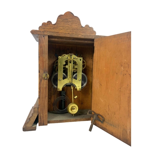 31 - Late Victorian Ansonia Clock Company oak clock. With key and pendulum. 28.5 x 14 x 40cm.