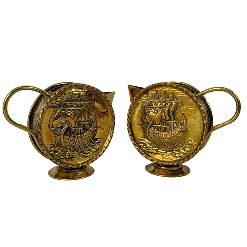 71 - Pair of vintage brass round handled pitchers with Viking longboat theme. Larger of the pair 22 x 18c... 