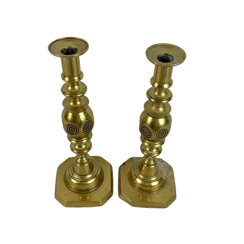 107 - Pair of Victorian brass bullseye candlesticks. 29cm.