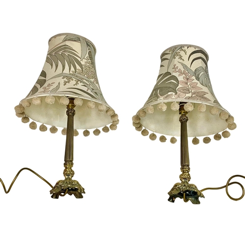 131 - Pair of ornate brass table lamps. Base measures 32cm. With shade 52cm.