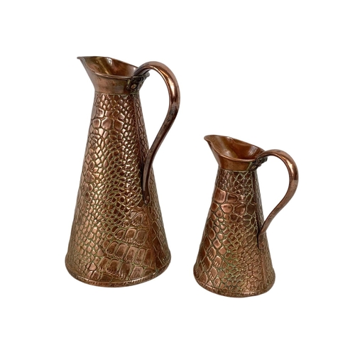 29 - 2 Arts & Crafts copper jugs by J.S&S. circa 1900. largest 26.5.