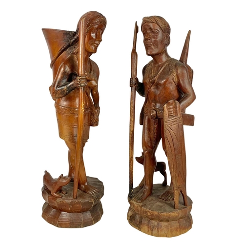 185 - A pair of tall carved wooden figures. 61cm