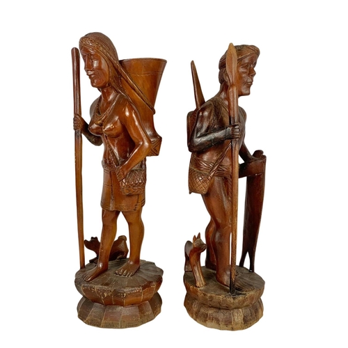 185 - A pair of tall carved wooden figures. 61cm