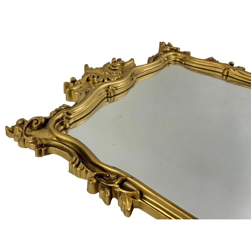 100 - Ornate gilt plastic frame mirror. 47 x 73cm