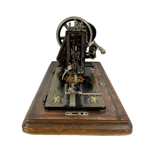 170 - A late Victorian hand turning sewing machine in an inlaid case. With Leo The Lion. Circa 1890/1900. ... 