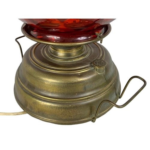 172 - A large vintage Wright & Butler Union Burner lamp with ruby glass shade. 32 x 43cm