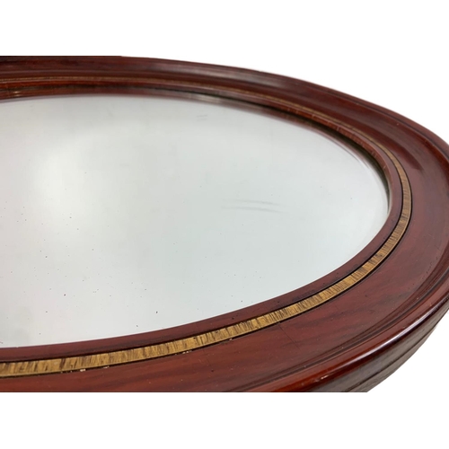 196 - An Edwardian mahogany framed oval mirror. 59 x 49cm