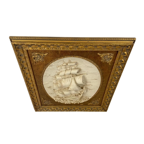 220 - A large ornate gilt framed plaque of a ship. 77 x 86cm