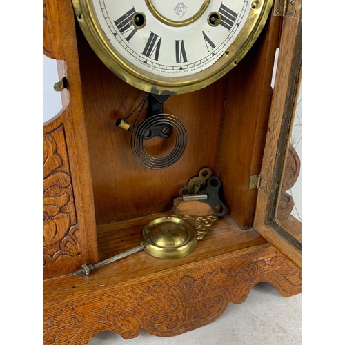 236 - A late 19th century American oak gingerbread clock. Circa 1880. 34 x 57cm.