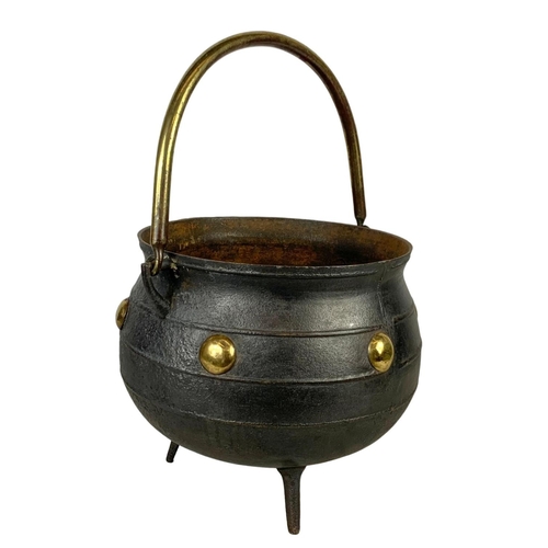 243 - A large early 20th century cast iron and brass 3 legged pot. 36 x 32 x 53cm including handle