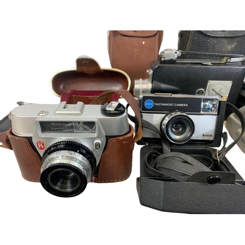 263 - Quantity of cameras. Including Kodak, Canon, Regula, Halina, Polaroid, Hanimex.