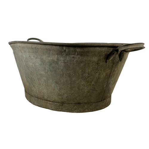 282 - A large early 20th century galvanised tub and a watering can. 85 x 55 x 32