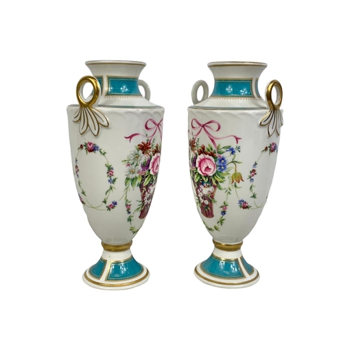 520 - A pair of Mintons Rose Basket porcelain urns. 22cm.