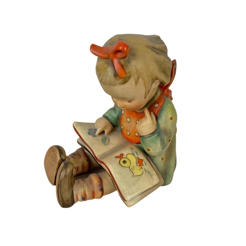 596 - A vintage M. J. Hummel Goebel pottery figure. “Bookworm” Germany 1930. 10 x 12cm