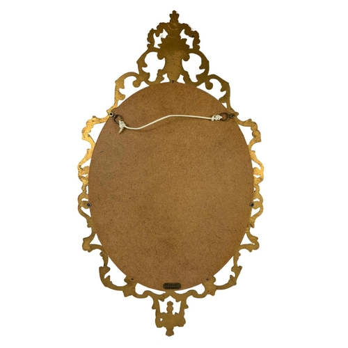 324e - An ornate brass framed mirror by Peerart. 43 x 78cm.