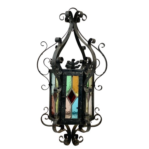 120 - A vintage wrought iron light fitting with stain glass. 29 x 60cm.