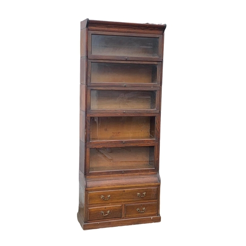 1004 - A large Edwardian oak stacking bookcase by Gumm. 87 x 35 x 221cm.