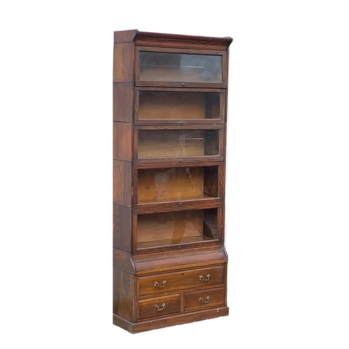 1004 - A large Edwardian oak stacking bookcase by Gumm. 87 x 35 x 221cm.