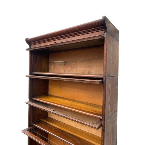 1004 - A large Edwardian oak stacking bookcase by Gumm. 87 x 35 x 221cm.