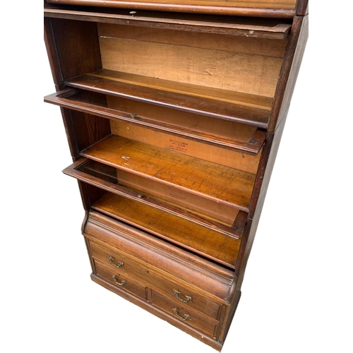 1004 - A large Edwardian oak stacking bookcase by Gumm. 87 x 35 x 221cm.