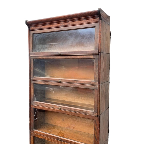 1004 - A large Edwardian oak stacking bookcase by Gumm. 87 x 35 x 221cm.