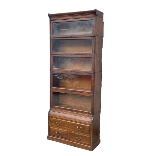 1004 - A large Edwardian oak stacking bookcase by Gumm. 87 x 35 x 221cm.