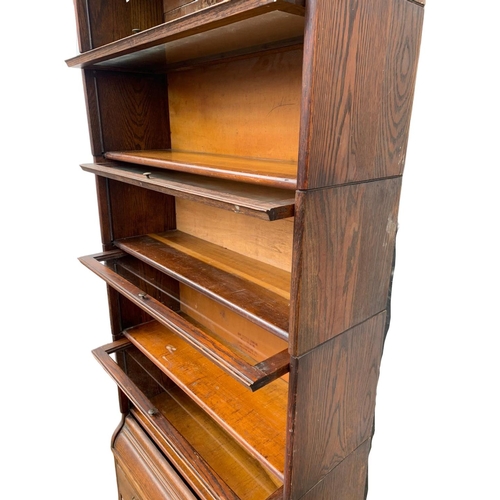 1004 - A large Edwardian oak stacking bookcase by Gumm. 87 x 35 x 221cm.