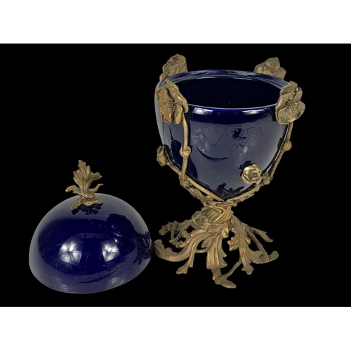 23 - A vintage ornate brass and blue porcelain egg jar and lid. 38cm.