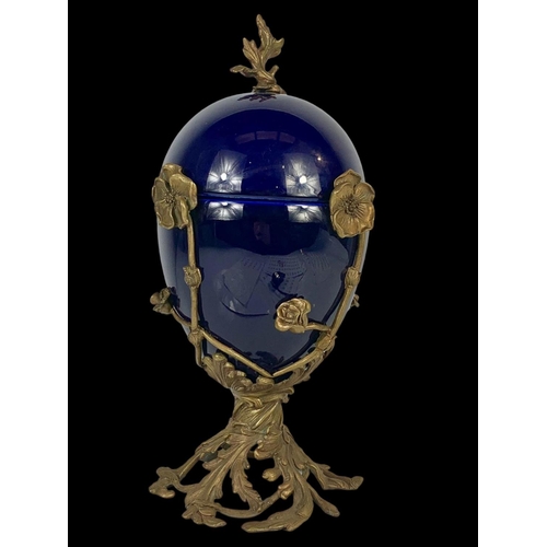 23 - A vintage ornate brass and blue porcelain egg jar and lid. 38cm.