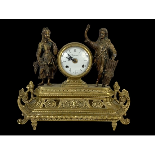 24 - A large vintage ornate brass clock set with candelabras. Clock measures 38 x 13.5 x 33.5cm. Candelab... 