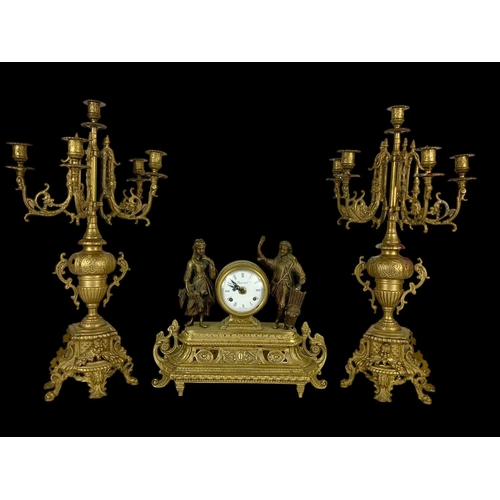 24 - A large vintage ornate brass clock set with candelabras. Clock measures 38 x 13.5 x 33.5cm. Candelab... 