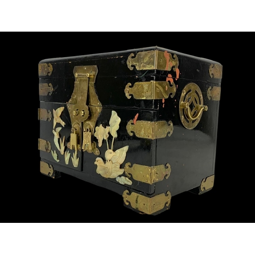 28 - An oriental style brass bound lacquered jewellery box faux ivory. 32 x 21 x 25cm.