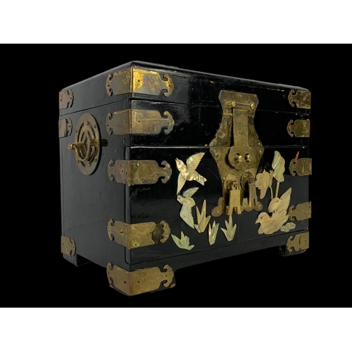 28 - An oriental style brass bound lacquered jewellery box faux ivory. 32 x 21 x 25cm.