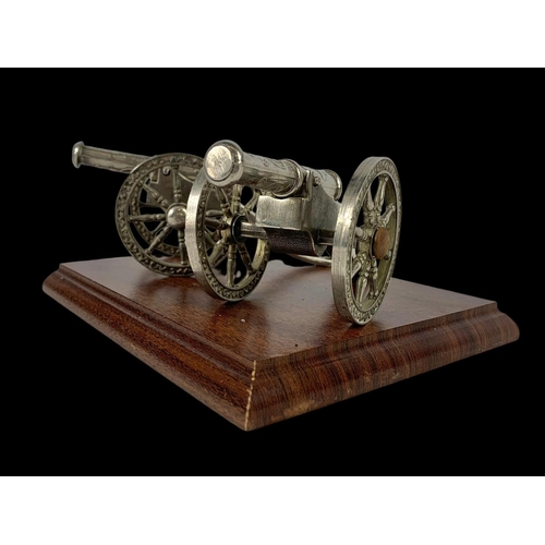 568 - A pair of silver plated cannons on a wooden plinth. 20.5 x 15.5 x 9cm.