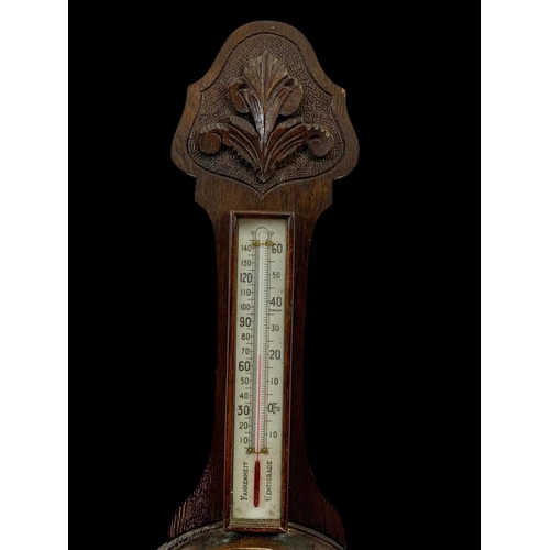 72 - An Edwardian carved oak barometer. 81cm.