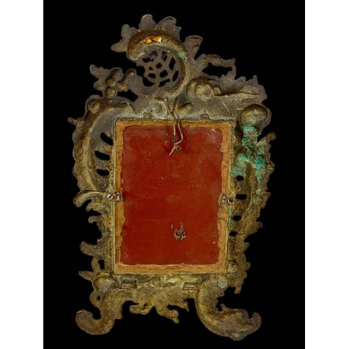 76 - A small Victorian ornate brass mirror. 19 x 31cm