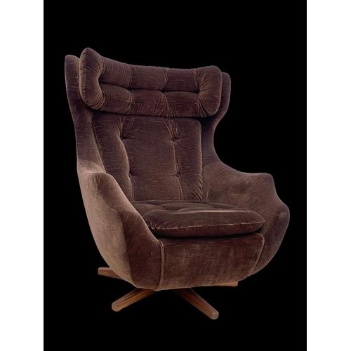 815 - A 1960’s “Statesman” wingback swivel chair by Parker Knoll on a teak base. Mid century 1960.