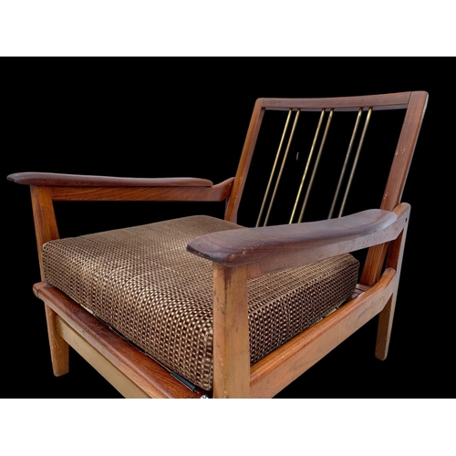 818 - A pair of teak armchairs with brass back rails and cushions. Mid century. Circa 1960’s. 72 x 65 x 70... 