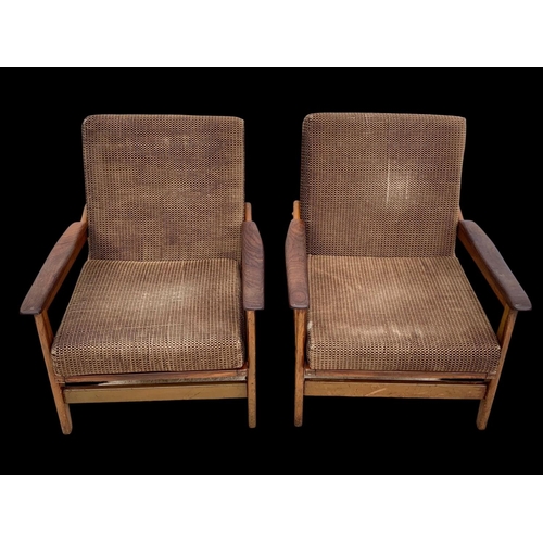 818 - A pair of teak armchairs with brass back rails and cushions. Mid century. Circa 1960’s. 72 x 65 x 70... 