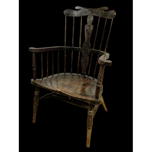 856 - A mid 19th century carved elm Windsor armchair. 73 x 50 x 106cm.