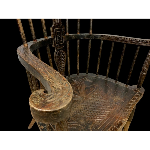 856 - A mid 19th century carved elm Windsor armchair. 73 x 50 x 106cm.