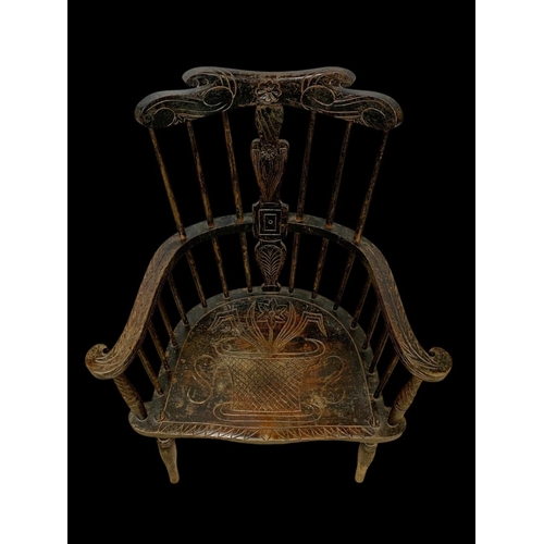 856 - A mid 19th century carved elm Windsor armchair. 73 x 50 x 106cm.