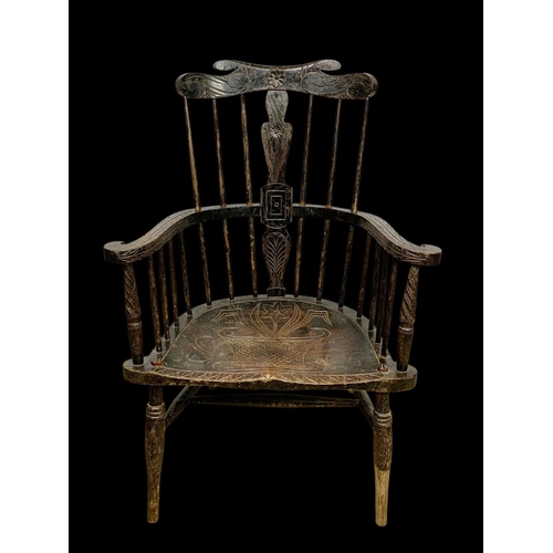 856 - A mid 19th century carved elm Windsor armchair. 73 x 50 x 106cm.