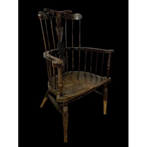 856 - A mid 19th century carved elm Windsor armchair. 73 x 50 x 106cm.